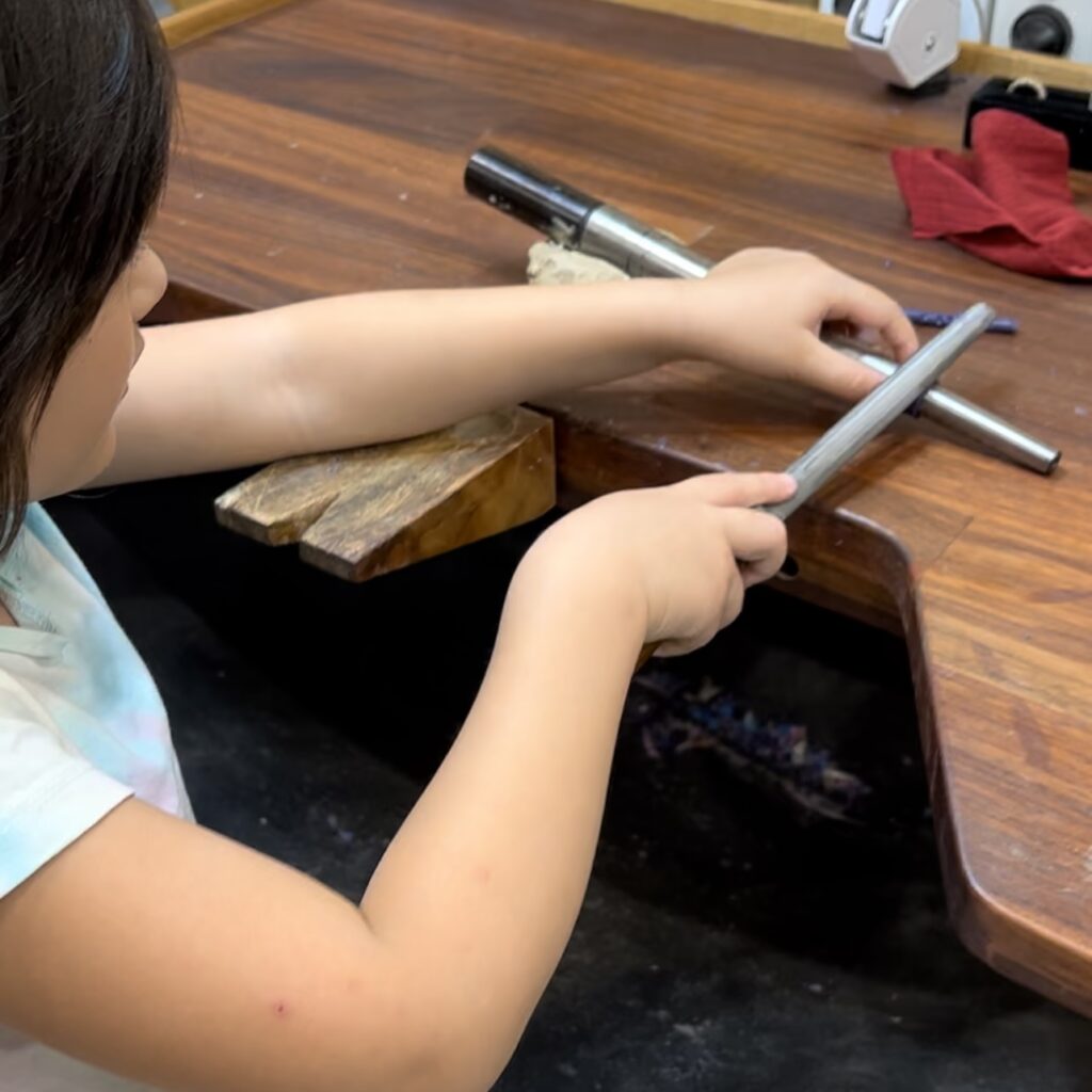 A little girl filing a ring