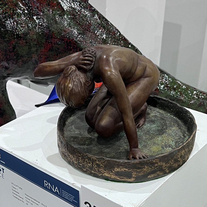 A bronze sculpture of a bathing woman