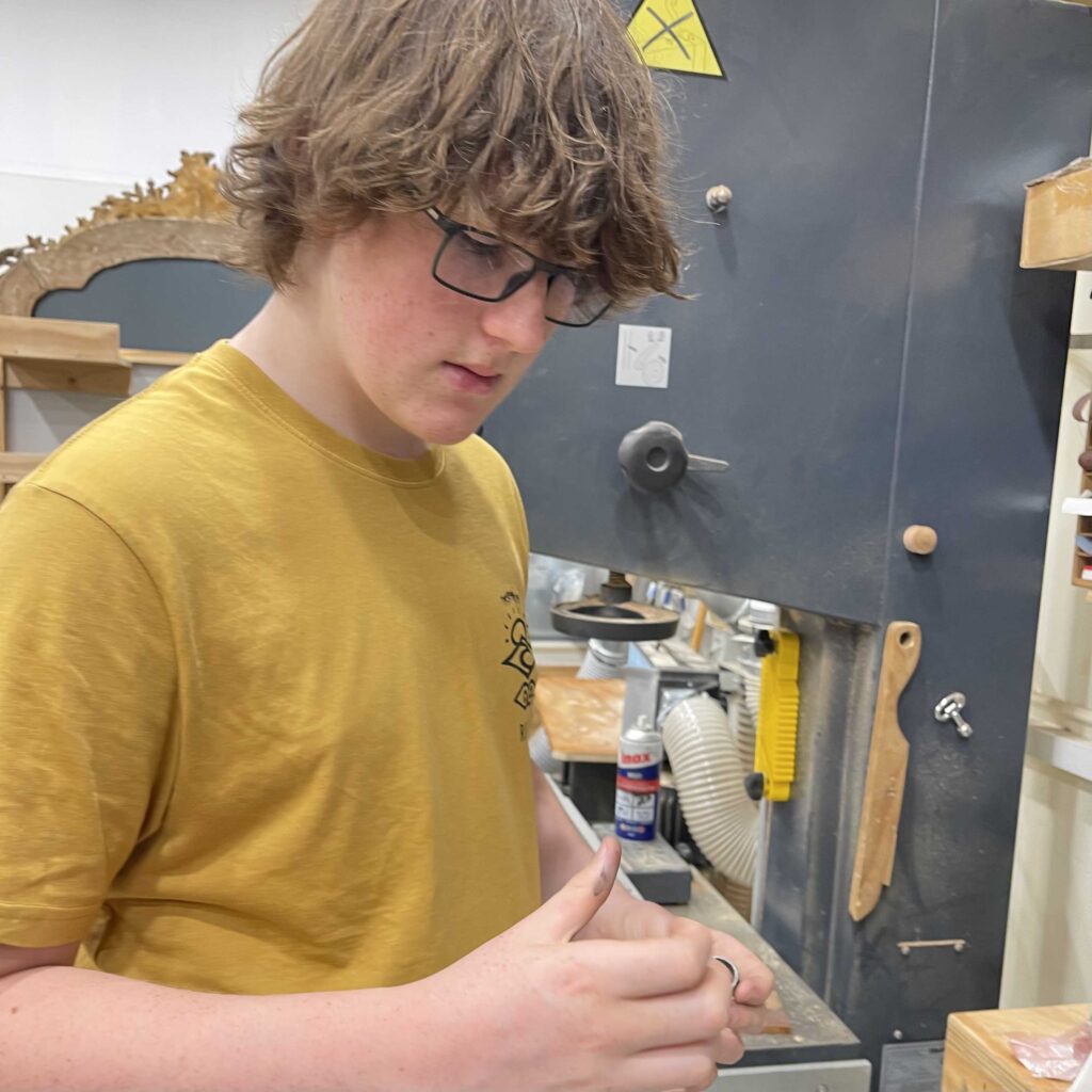 young boy making jewellery